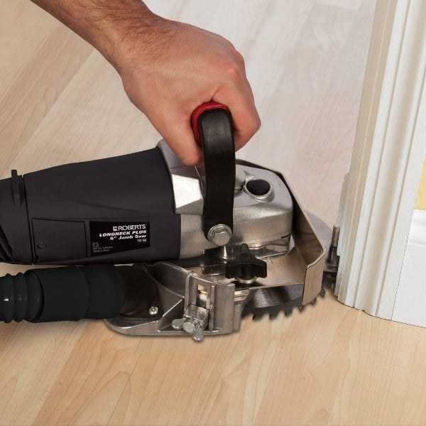Person using a circular saw to cut baseboards on a wooden floor.