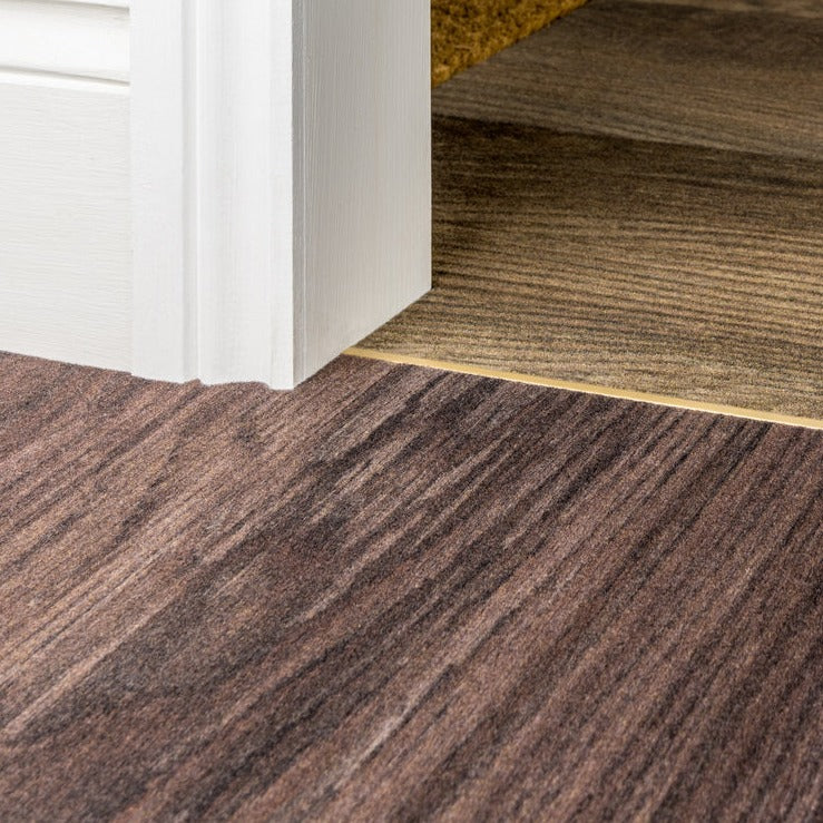 Close-up of floor transition with Stairrods Premier Dividers between brown and beige carpet sections