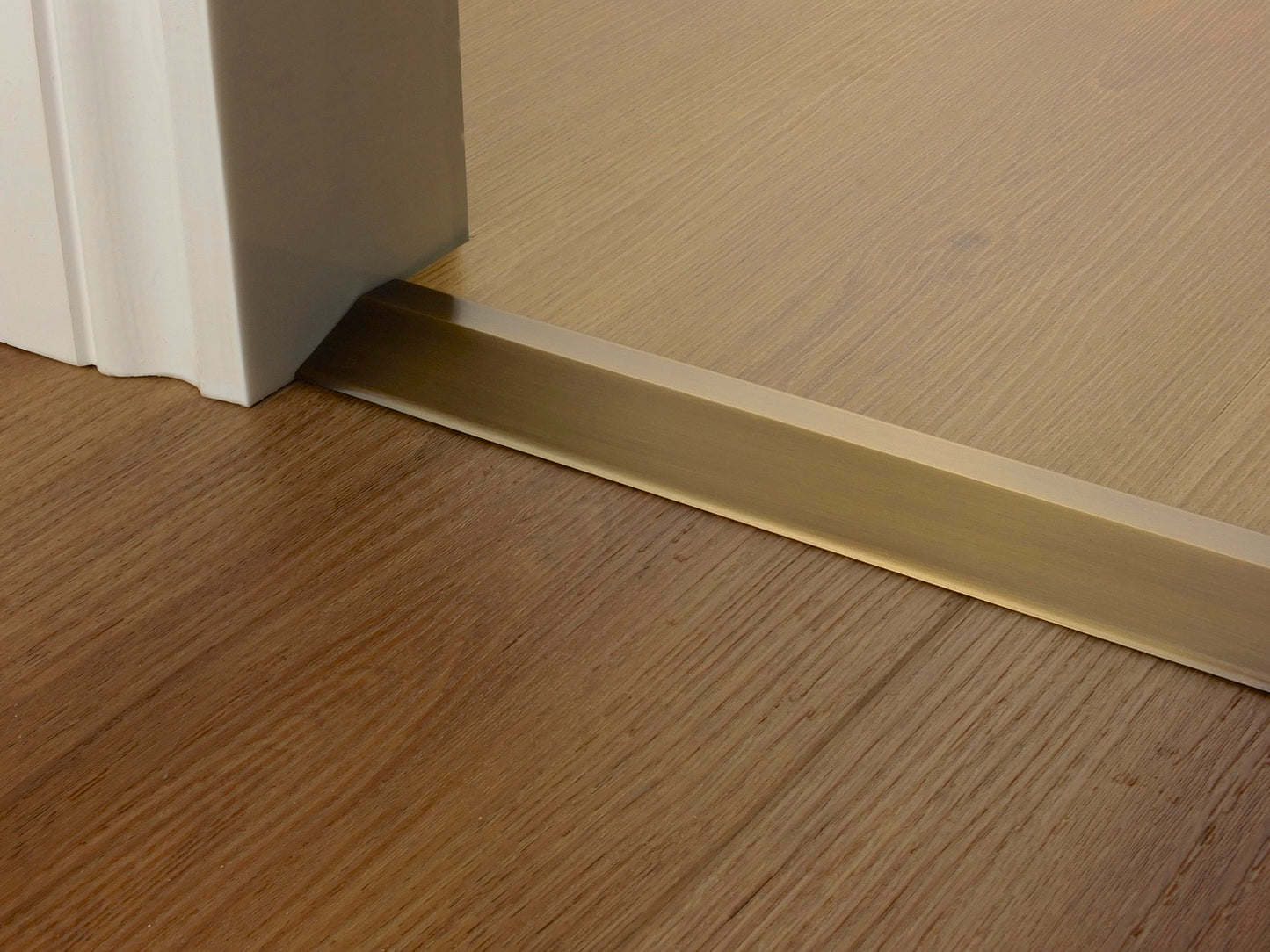 Stairrods Premier Ramp Flooring Trim door bar installed between two wooden floors under a white door frame