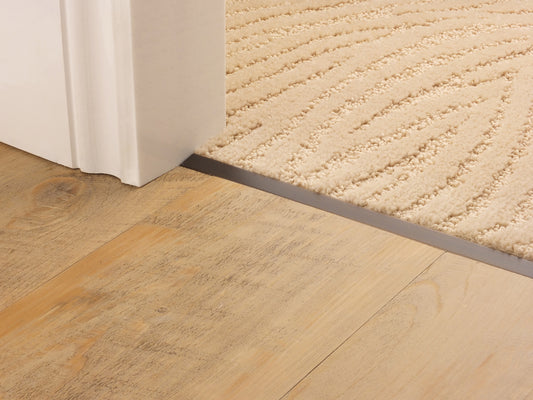 Stairrods Premier Square Trim door bar installed between wooden flooring and beige carpet under doorway