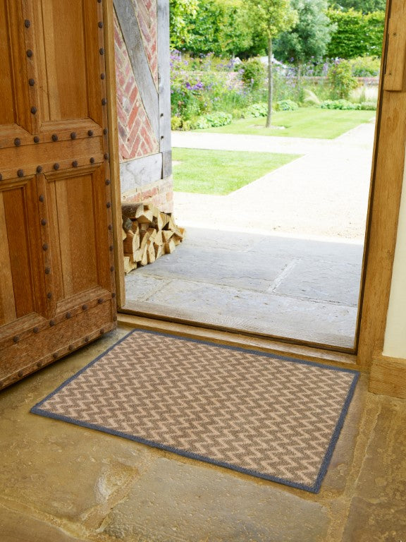 Turtle Mats Cotswold Weave Door Mat placed at an open wooden door entrance with garden view