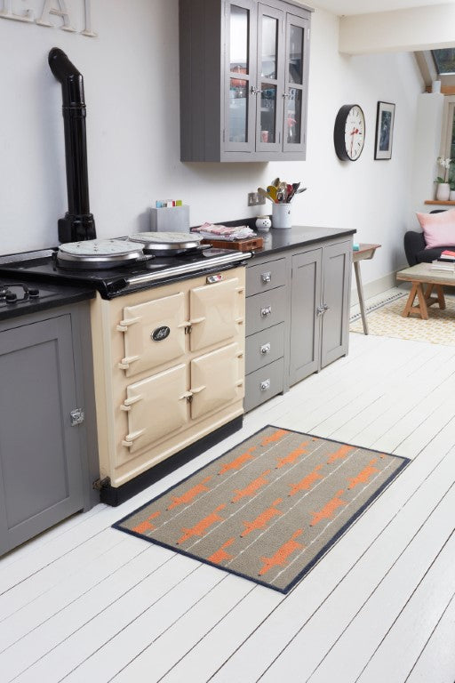 Turtle Mats Running Mr Fox Design floor mat placed on white wooden kitchen floor near cream cooker