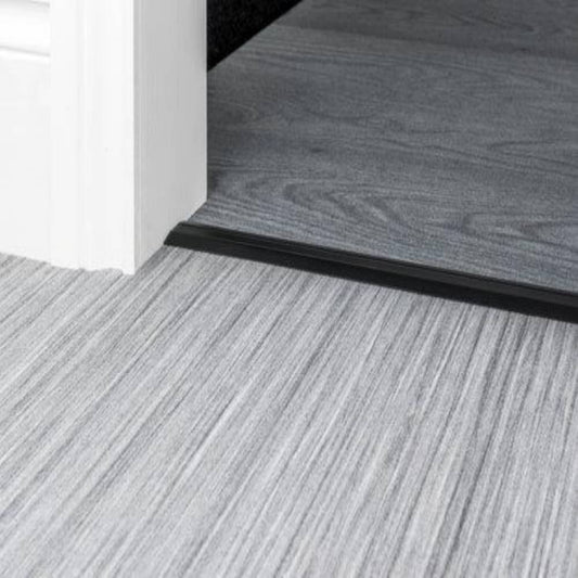 Stairrods Premier Posh Flooring Trim in black metal separating grey wood and laminate flooring
