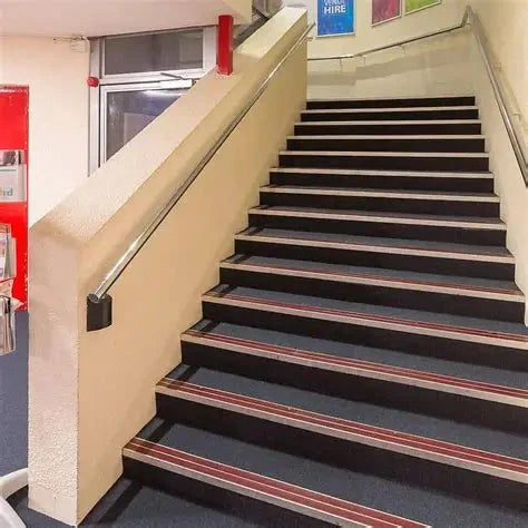 Measuring Stair Nosings on Black and Grey Carpeted Stairs for Enhanced Safety in Commercial Spaces