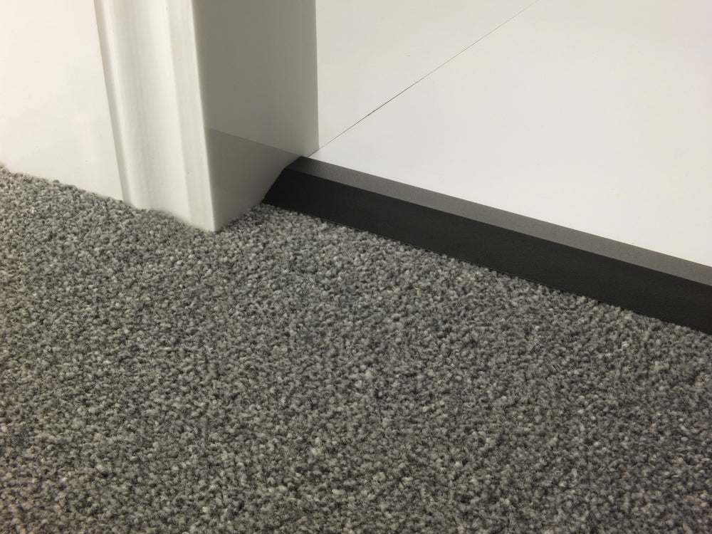 Stairrods Premier Carpet Ramp Flooring Trim in black installed between grey carpet and white flooring