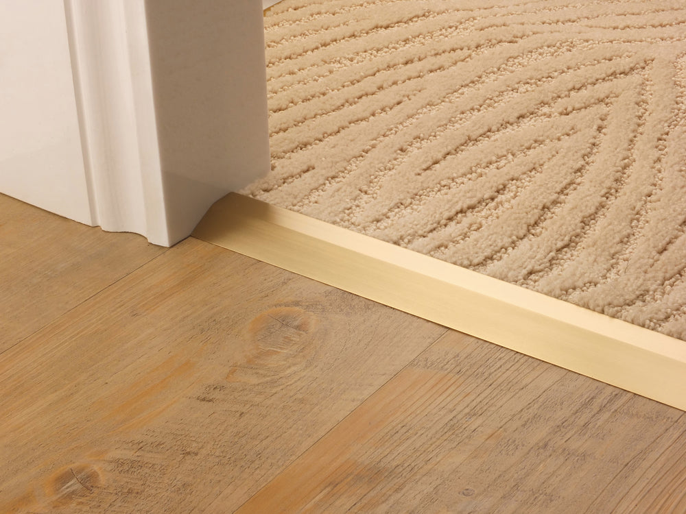 Stairrods Premier Carpet Ramp Flooring Trim in gold finish installed between wooden floor and beige carpet