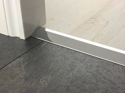 Stairrods Premier Ramp Flooring Trim in silver installed between grey tile and light wood flooring under a door