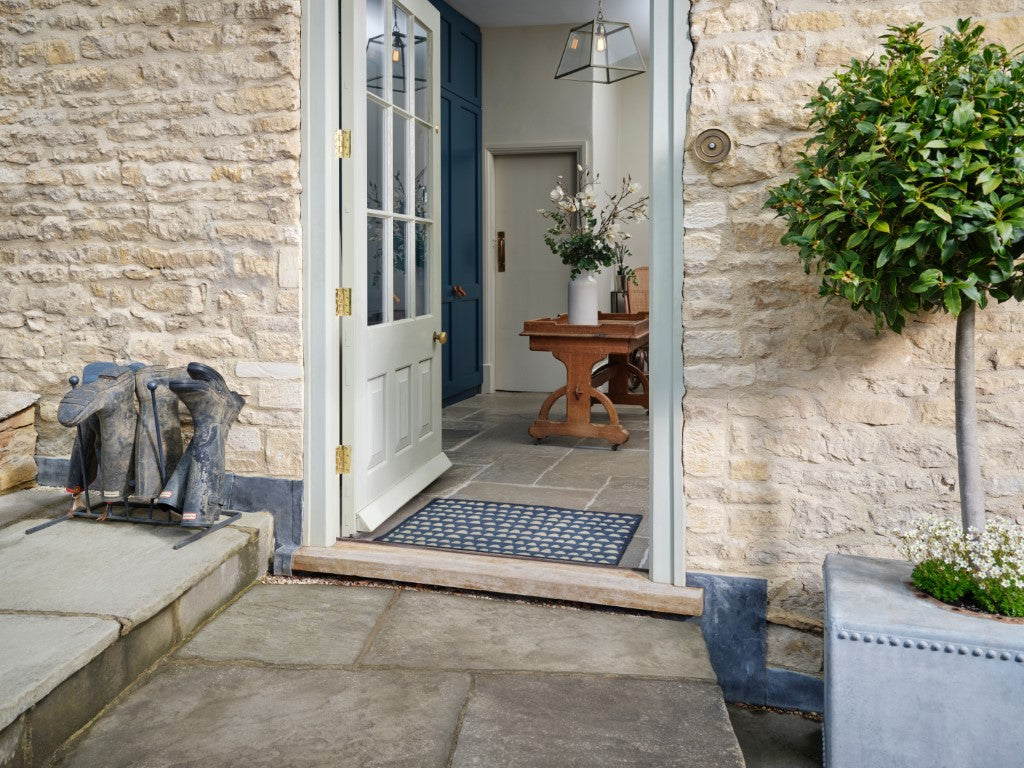 Turtle Mats Priya Door Mat with geometric pattern placed at open front door on stone patio