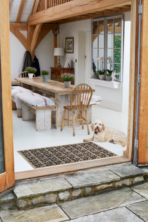 Turtle Mats - ROSEHIP Design floor mat placed in a bright rustic dining room with wooden table and dog nearby