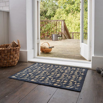 Turtle Mats - ROSEHIP Design floor mat with leaf pattern placed on wooden floor by open door