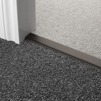 Stairrods Premier DoubleZ Flooring Trim in metallic finish joining grey and beige carpet edges near door frame